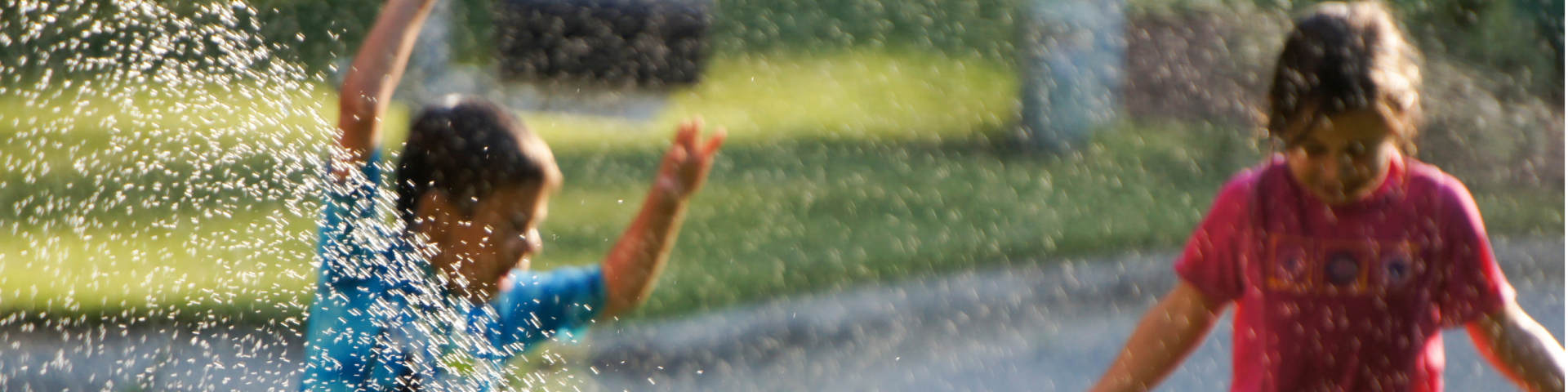 Children playing in sprinkler water