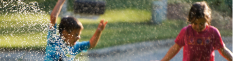 Children playing in sprinkler water